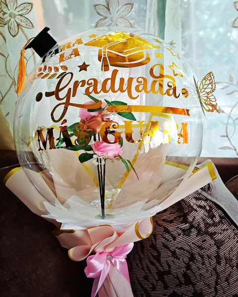 Globo de graduación con frase personalizada y rosas eternas en vinil dorado.